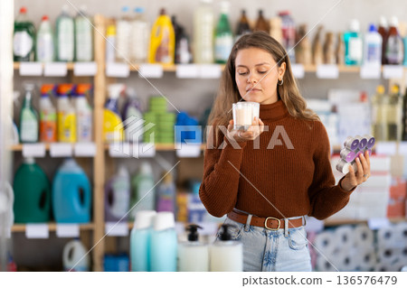 Young woman choosing scented candles in store Young woman choosing scented candles in store 136576479