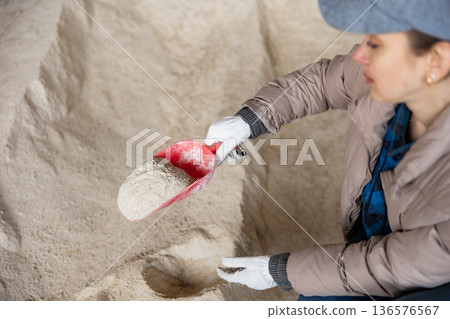 Woman farmer checking quality of corn flour 136576567