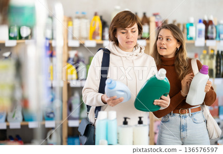 Mum with adult daughter purchases household chemicals in store, choose liquid detergent Mum with adult daughter purchases household chemicals in store, choose liquid detergent 136576597