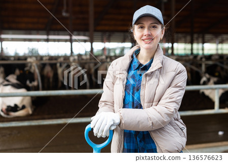 Smiling female farmer posing at dairy farm Smiling female farmer posing at dairy farm 136576623