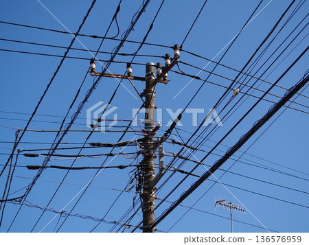 Electric wires against a blue sky Electric wires against a blue sky 136576959