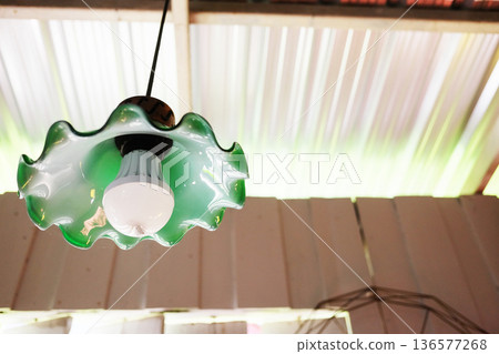 Vintage green lamp hang above on ceiling of an abandoned house. Copy space 136577268