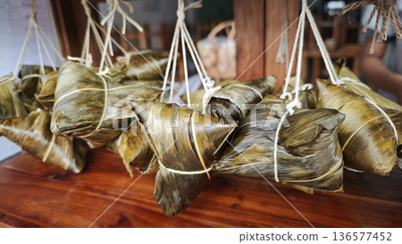 Zongzi, an ancient Chinese traditional dish wrapped in fragrant leaves, crafted with fine ingredients and cherished in cultural festival rituals. Zongzi, an ancient Chinese traditional dish wrapped in fragrant leaves, crafted with fine ingredients and cherished in cultural festival rituals. 136577452