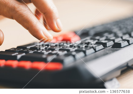 Close-up of fingers typing on computer keyboard for data entry and online work. Technology, communication and productivity concept with shallow depth of field and copy space background. Close-up of fingers typing on computer keyboard for data entry and online work. Technology, communication and productivity concept with shallow depth of field and copy space background. 136577638