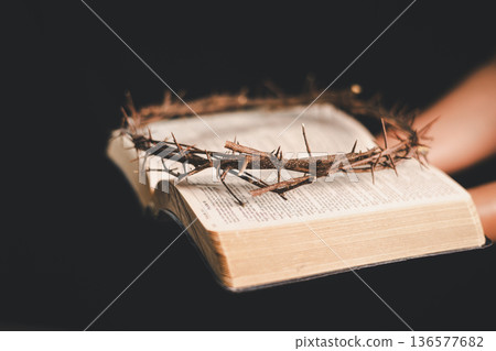 Hand offering an iron nail and crown of thorns on dark background, dramatic light with copy space, symbolizing crucifixion, sacrifice, Good Friday, Holy Week and Easter faith for believers worldwide. Hand offering an iron nail and crown of thorns on dark background, dramatic light with copy space, symbolizing crucifixion, sacrifice, Good Friday, Holy Week and Easter faith for believers worldwide. 136577682