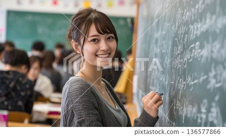 一位兼職大學生講師在黑板前授課，學生們正在記筆記，這是冬季課程提供的補習學校工作招募的視覺素材。 136577866