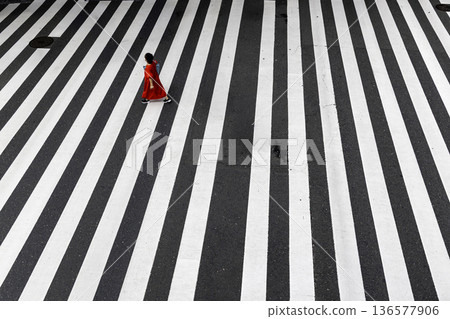 A summer crosswalk, a woman in red clothes crossing alone 136577906