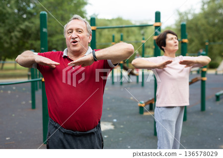 Sports pensioners do a warm-up on outdoor sports ground Sports pensioners do a warm-up on outdoor sports ground 136578029