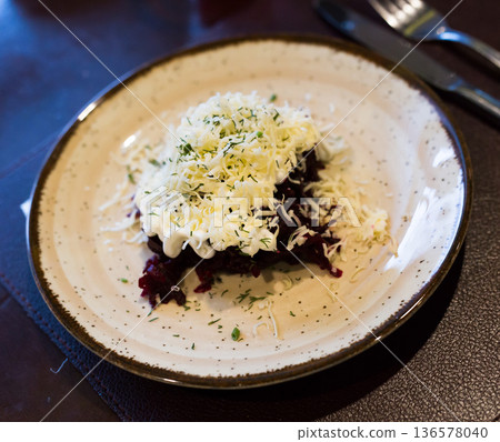 mix of beets, cheese, mayonnaise on a plate in restaurant 136578040