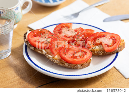 two bruschettas with tomato slices on a plate two bruschettas with tomato slices on a plate 136578042