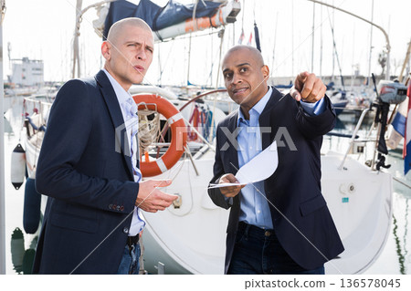 men in suits buy and sell a yacht in the seaport 136578045