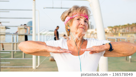 Old woman doing fitness exercises outdoors Old woman doing fitness exercises outdoors 136578049