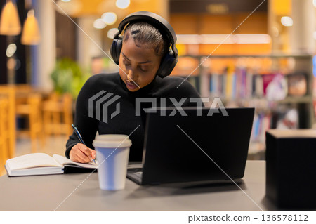 Student studying diligently in a library 136578112