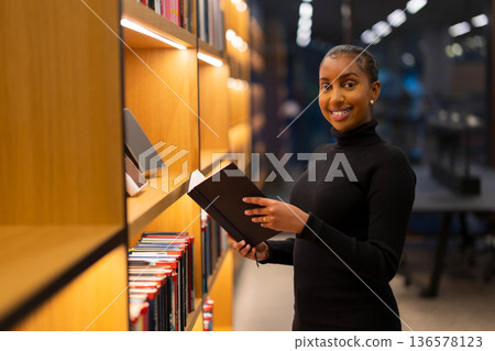 Student reading in a modern library Student reading in a modern library 136578123