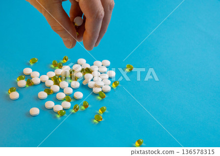 Hand Holding Pills And Capsules On Blue Hand Holding Pills And Capsules On Blue 136578315