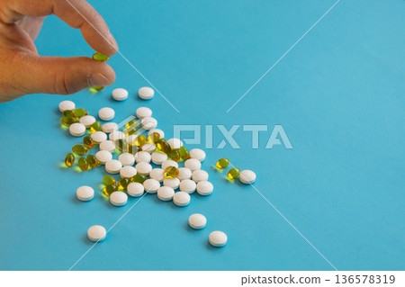 Hand Holding Pills And Capsules On Blue Hand Holding Pills And Capsules On Blue 136578319