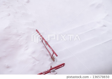 Snow-covered red railings on staircase Snow-covered red railings on staircase 136578650