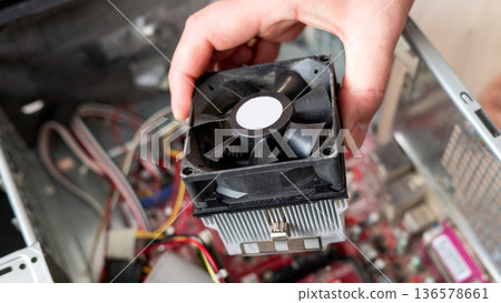 Hand inspecting a computer cpu fan in open desktop case Hand inspecting a computer cpu fan in open desktop case 136578661