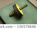 Abdominal roller on green mat for core exercise and strength training 136578686