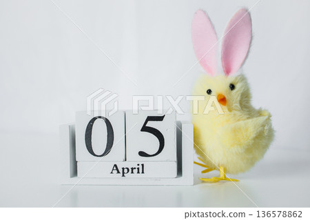 Christian Catholic Easter 2026 date on a wooden calendar with funny small Easter chick toy on white background close up Christian Catholic Easter 2026 date on a wooden calendar with funny small Easter chick toy on white background close up 136578862