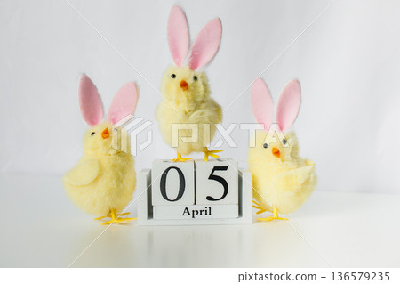 Christian Catholic Easter 2026 date on a wooden calendar with three funny small Easter toy chicks on white background Christian Catholic Easter 2026 date on a wooden calendar with three funny small Easter toy chicks on white background 136579235