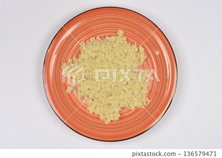 Cooked white rice on an orange plate top view Cooked white rice on an orange plate top view 136579471