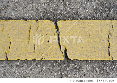 Cracked Yellow Road Line on Asphalt Cracked Yellow Road Line on Asphalt 136579496