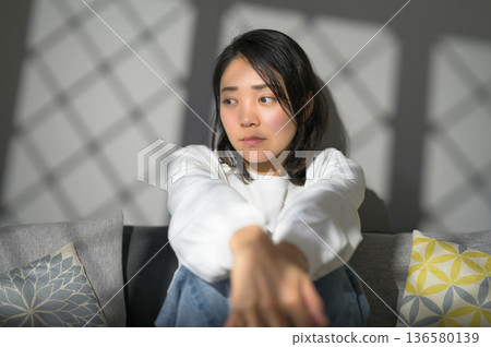 A melancholic Japanese woman at home 136580139