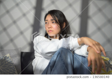 A melancholic Japanese woman at home 136580140