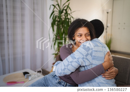 Two Teenagers Embracing on the Sofa at Home, Showing Love and Affection Two Teenagers Embracing on the Sofa at Home, Showing Love and Affection 136580227