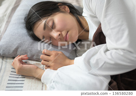 Sleeping face of a Japanese woman sleeping in bed 136580280