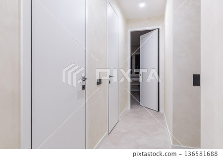 Modern Perspective of a Bright Hallway with Multiple White Doors Modern Perspective of a Bright Hallway with Multiple White Doors 136581688