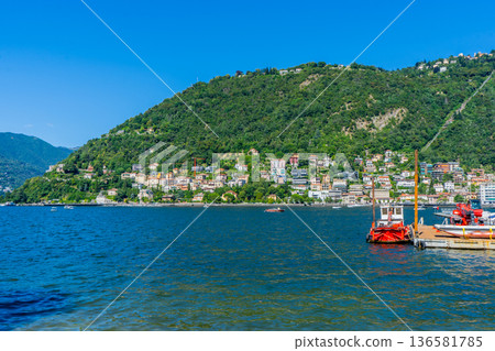 Como lake water in Summer day. Multicolor houses on green mountains Italian travel. Italy 136581785