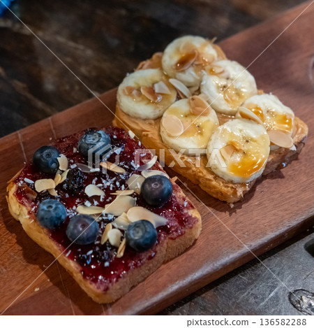 Bread topped with jam, blueberry and fresh banana slices 136582288