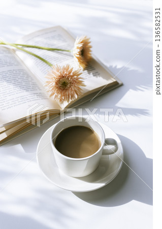 Gerberas, coffee, and reading - Morning sunshine filtering through the trees Gerberas, coffee, and reading - Morning sunshine filtering through the trees 136582531