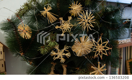 Straw Christmas Ornaments on Tree. Home winter decor Straw Christmas Ornaments on Tree. Home winter decor 136583208