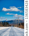 一條筆直的雪路通往山區。北海道晴朗陽光下的景色。 136583428