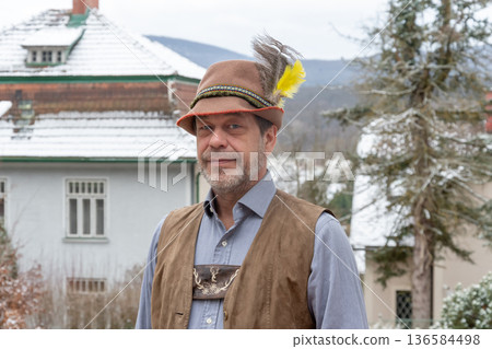 Adult man in Tyrolean hat and vest posing outdoors in winter in rural Europe Adult man in Tyrolean hat and vest posing outdoors in winter in rural Europe 136584498