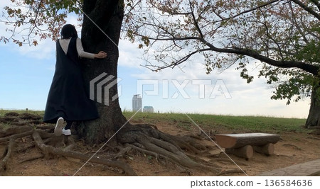 A woman standing under a tree 136584636