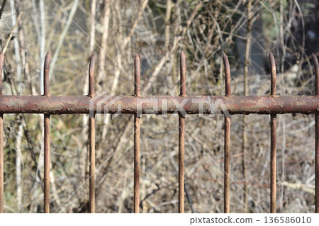 Rusty spiked metal fence outdoors Rusty spiked metal fence outdoors 136586010