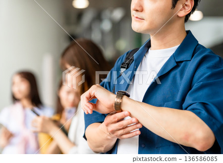 The man checks his watch. Photo courtesy of Kansai International Airport (KIX) The man checks his watch. Photo courtesy of Kansai International Airport (KIX) 136586085