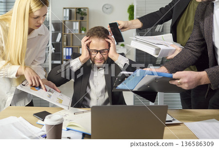 Stressed manager overwhelmed by multitasking, paperwork, and deadlines at office 136586309