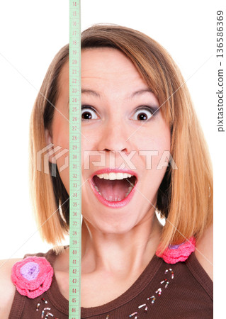 Beautiful young caucasian woman measuring her body with tape isolated Beautiful young caucasian woman measuring her body with tape isolated 136586369