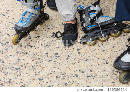 Woman putting on roller skates outdoor. 136586534