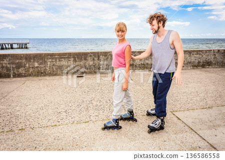 Friends learn rollerblading together have fun at park. Friends learn rollerblading together have fun at park. 136586558