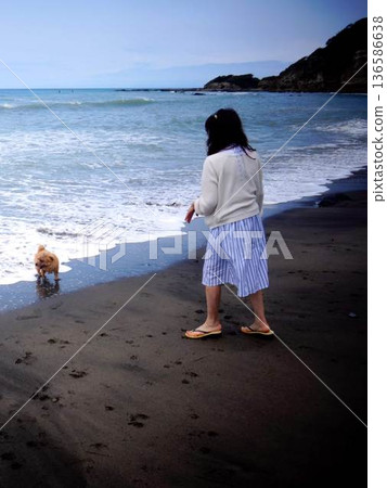 A woman walking along the beach A woman walking along the beach 136586638