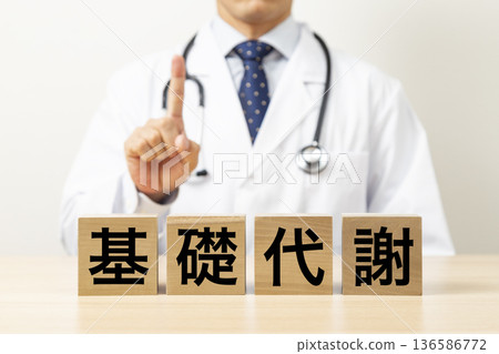 一塊寫著「基礎代謝」的牌子和一個醫生 136586772