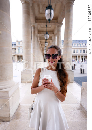 Woman using smartphone with coffee in Paris 136586873