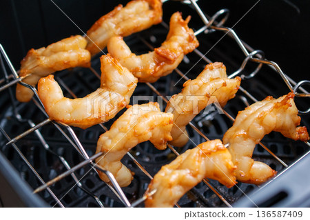 Golden Brown Shrimp Cooking in an Air Fryer for a Healthy Meal 136587409