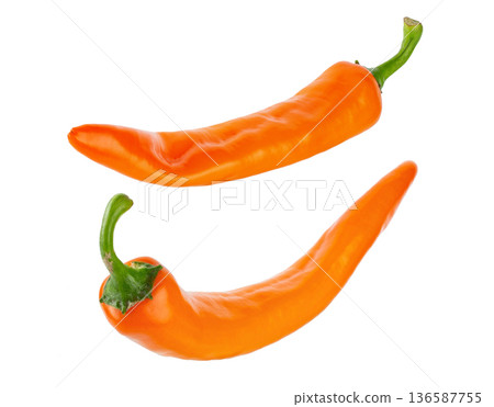 Two fresh orange chili peppers isolated on white background. Two fresh orange chili peppers isolated on white background. 136587755